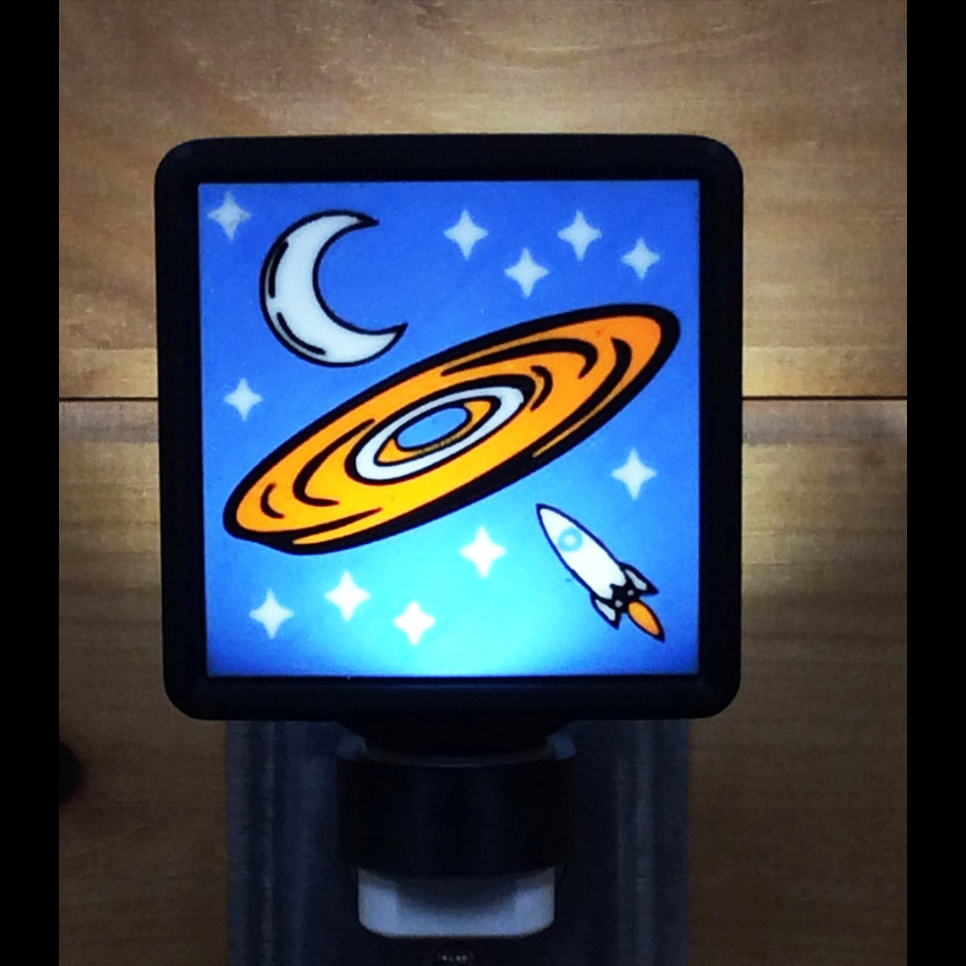 Decorative night light with a UFO, moon, and rocket design on a blue background.