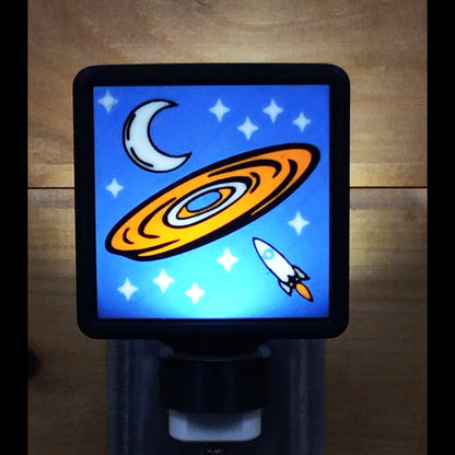 Decorative night light with a UFO, moon, and rocket design on a blue background.