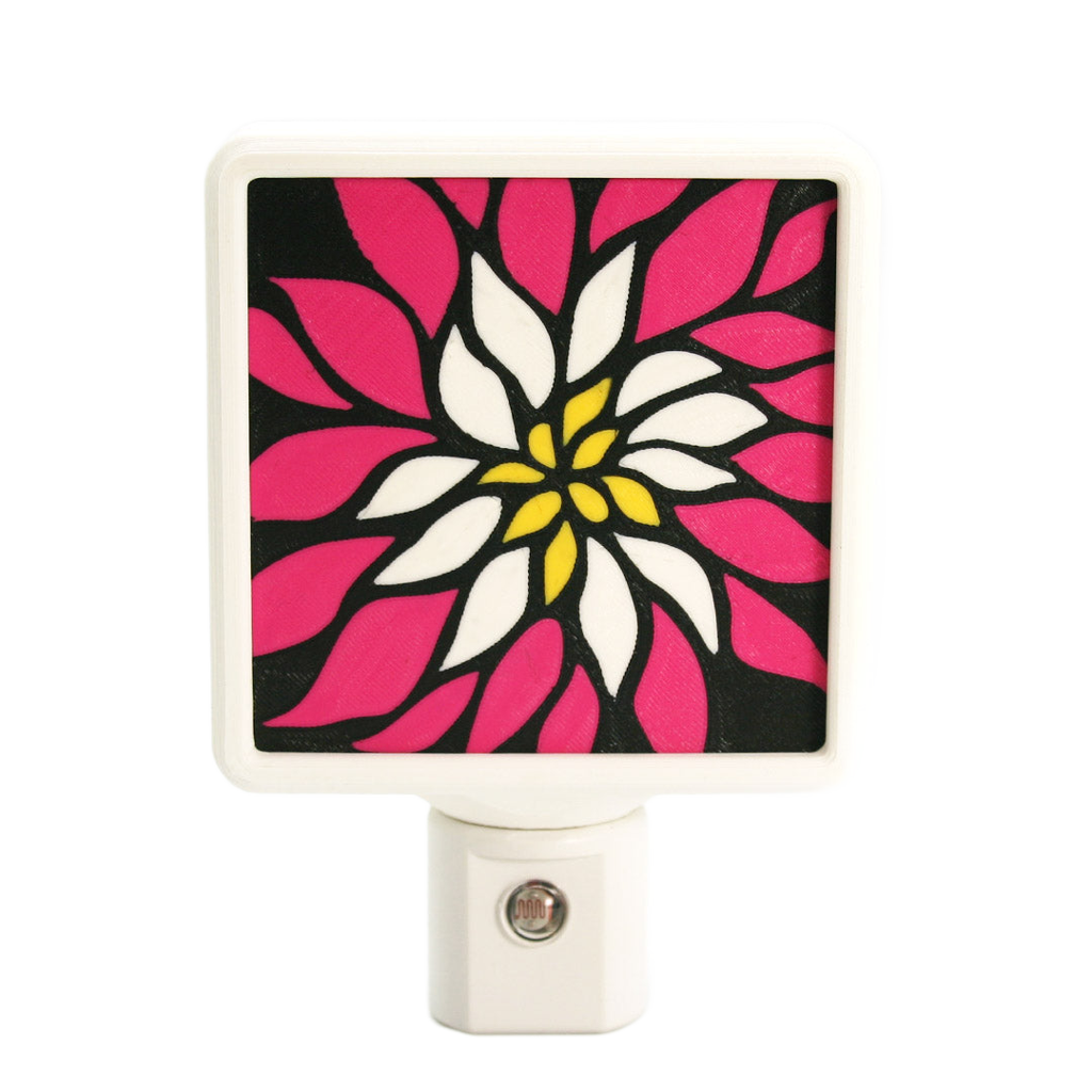 Colorful floral night light with pink, white, and yellow design on a black background.